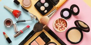 Vários cosméticos dispostos sobre uma superfície colorida